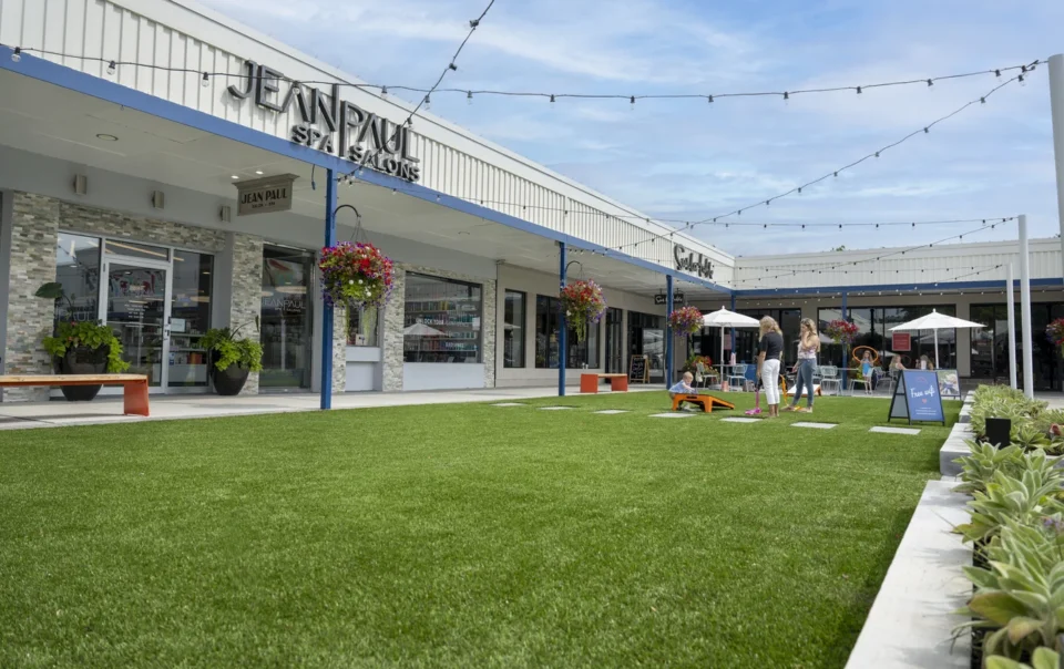 Stuyvesant Plaza outdoor courtyard with lawn, retail storefronts, and site design featuring green space and seating