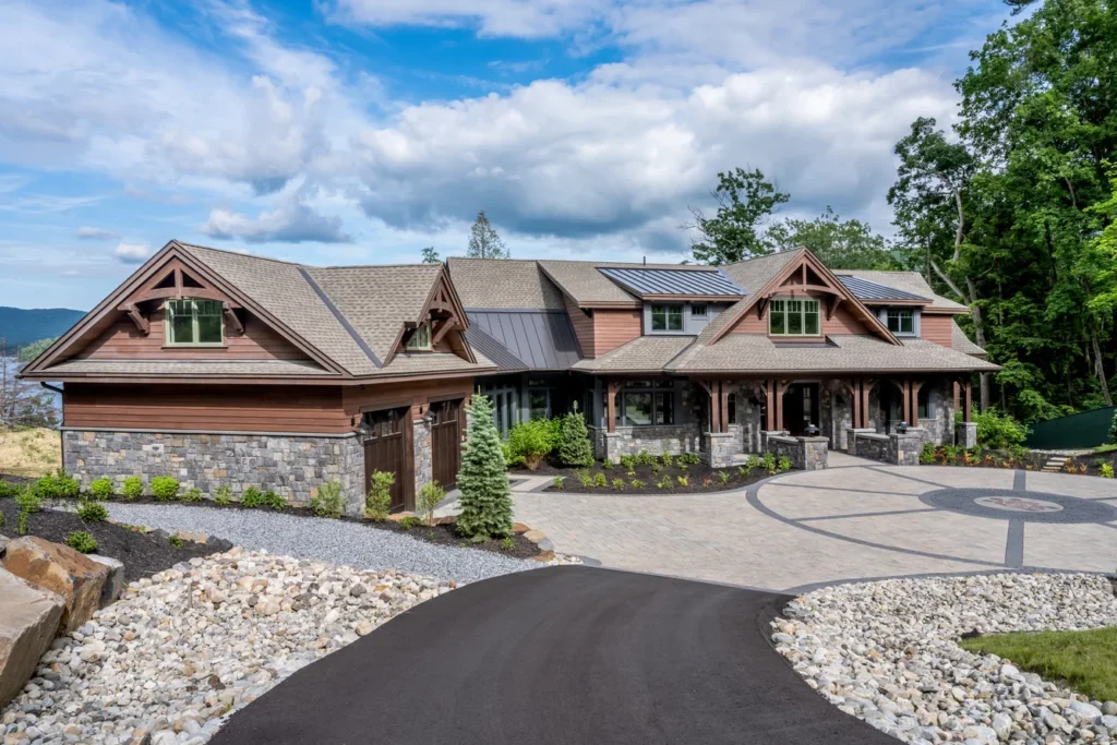 Modern residential estate with curved driveway, stone veneer facade, and integrated landscape architecture design in