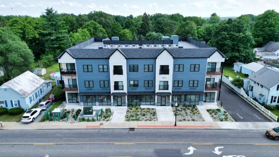 Multi-story mixed-use building with streetscape landscaping and sustainable site design on Main Street